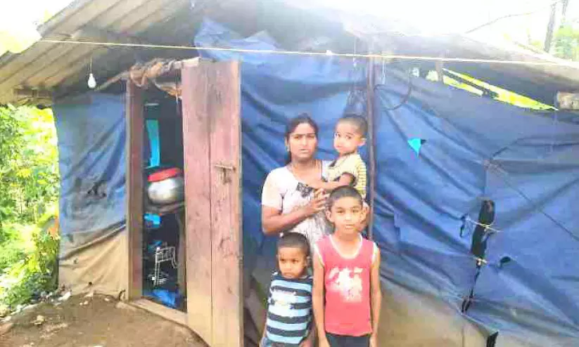 family infront of a poor home