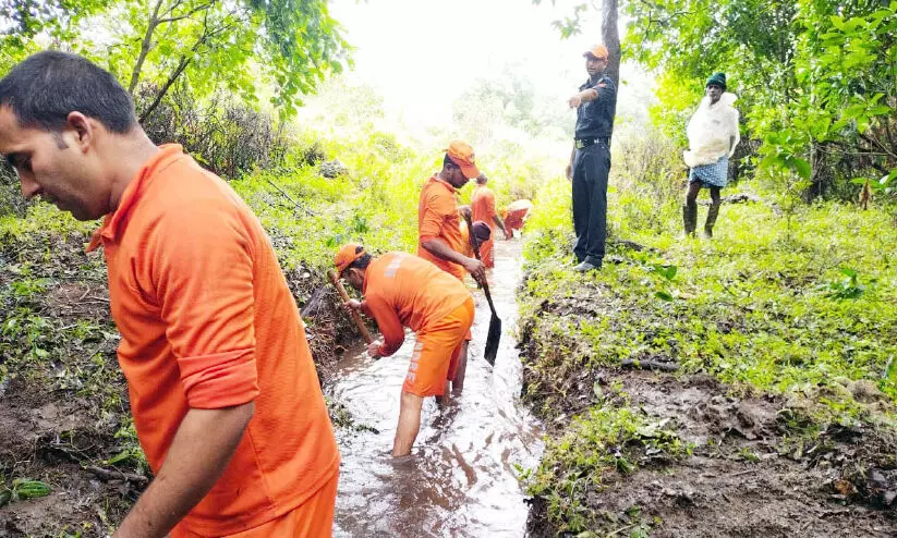 മ​ണ്ണി​ടി​ച്ചി​ൽ ഭീ​ഷ​ണി; മ​ല​മു​ക​ളി​ലെ വെ​ള്ളം ഒ​ഴു​ക്കി​ക്കള​ഞ്ഞ്   എ​ൻ.​ഡി.​ആ​ർ.​എ​ഫ് സം​ഘം