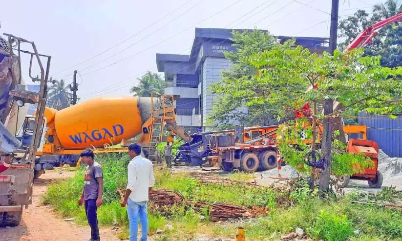 വ​ാഗ​ഡി​ന്റ വാ​ഹ​ന​ത്തി​ൽനി​ന്ന് സ്വ​കാ​ര്യ വ്യ​ക്തി​യു​ടെ നി​ർ​മാ​ണ​സ്ഥ​ല​ത്തേ​ക്ക്  കോ​ൺ​ക്രീ​റ്റ് മി​ക്സ് മാ​റ്റു​ന്നു