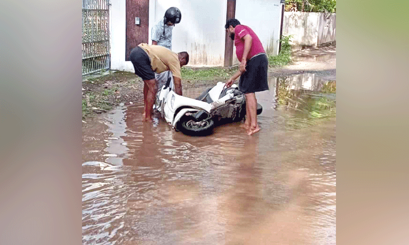 റോഡിലെ വെള്ളക്കെട്ടിൽ സ്കൂട്ടർ യാത്രികൻ വീണു